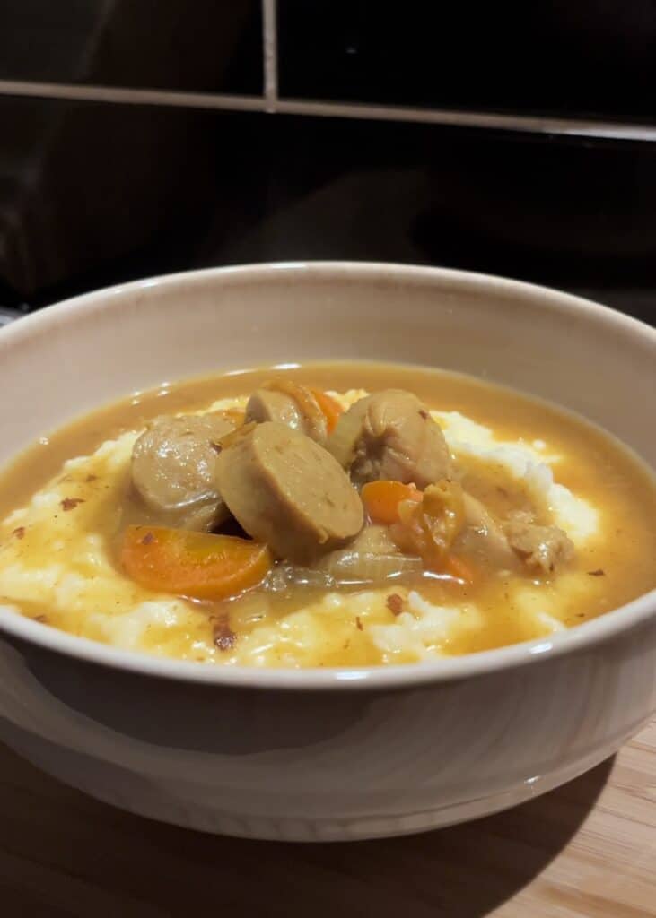 curried sausages with a chicken stock gravy, onion and carrot. served over creamy mashed potatoes