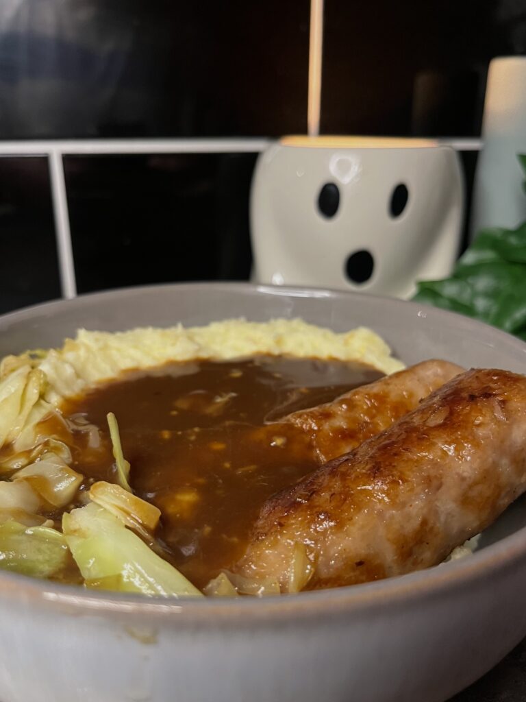 bangers n mash, pork sausages with cheesy mashed potato, cabbage, and gravy