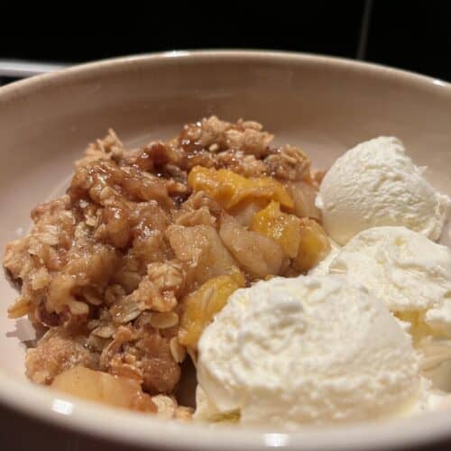 peach and apple crumble with oat and walnut topping, served warm with vanilla ice cream