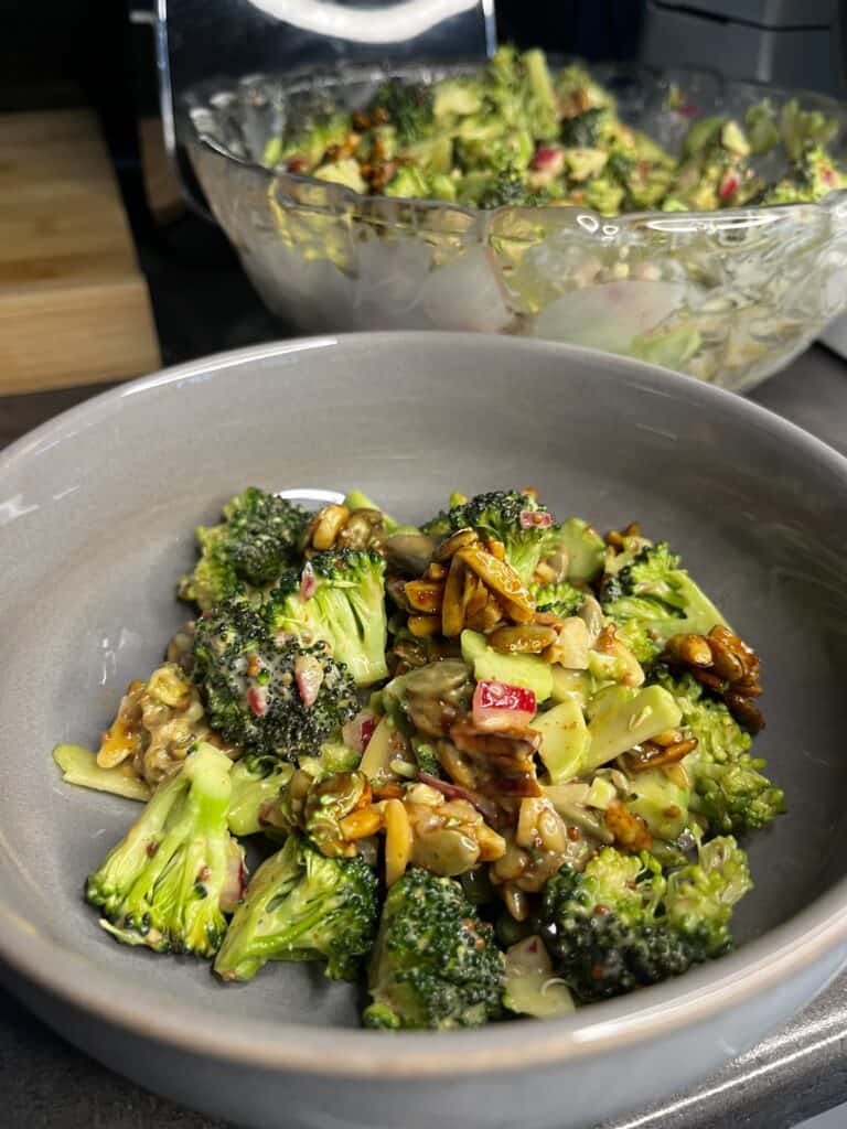 freshly made broccoli salad with almond, pumpkin seeds, pickled red onions, and salad dressing