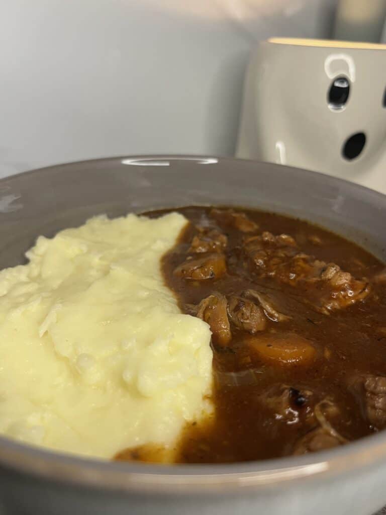 red wine chicken stew with chicken thighs, carrot, onion. served with creamy and cheesy mashed potatoes