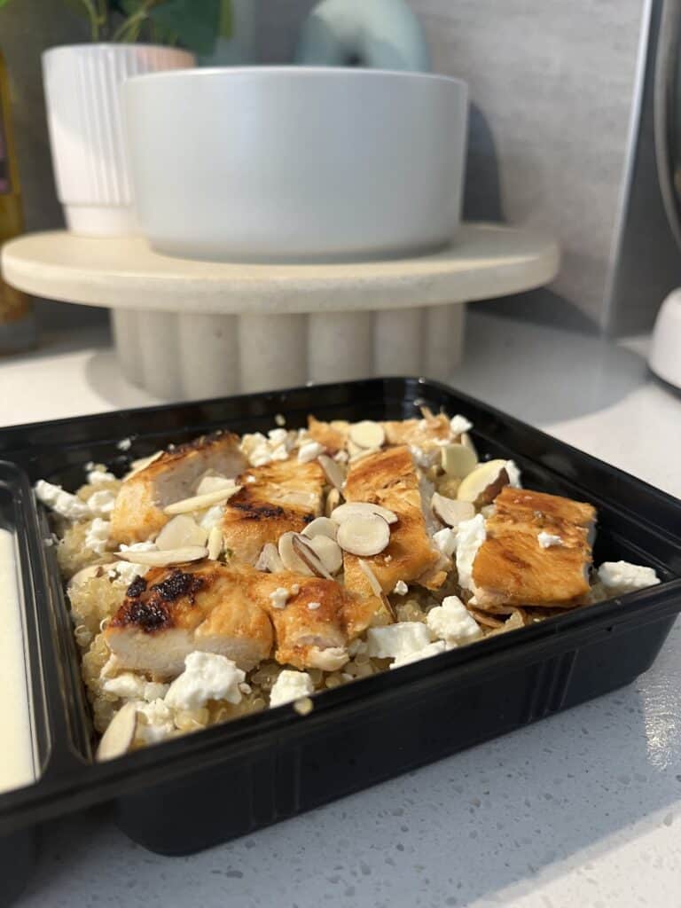 chicken and quinoa meal preparation with feta and almonds, and a lemon honey yoghurt dressing