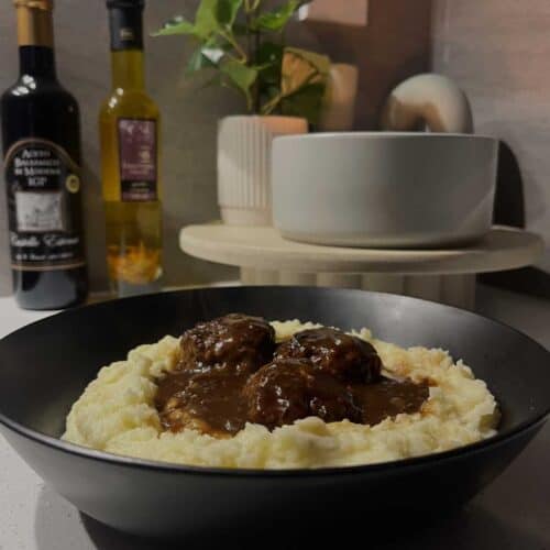 baked lamb meatballs and onion gravy on cheesy mashed potatoes