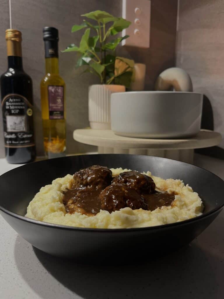 baked lamb meatballs and onion gravy on cheesy mashed potatoes