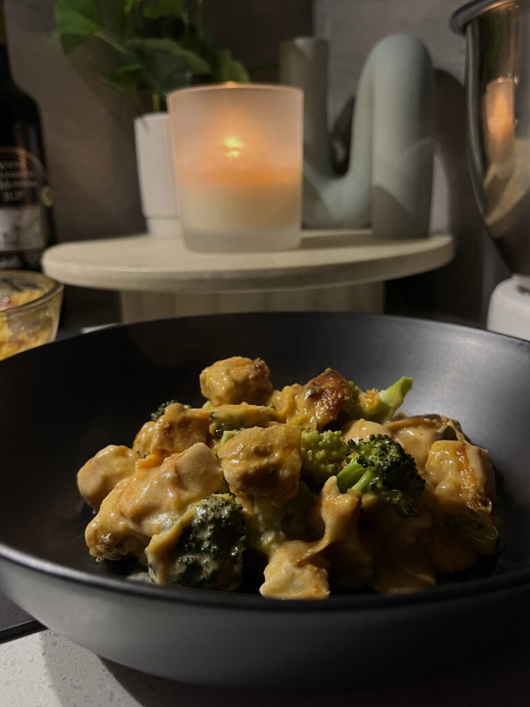 chicken and bacon broccoli back in a black bowl with a parmesan alfredo sauce